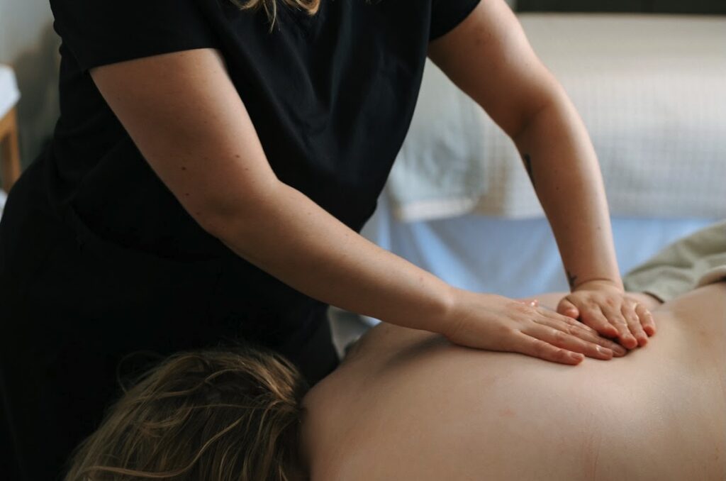 Licensed massage therapist performing deep tissue medical massage therapy on client’s back in Ocean County NJ spa setting