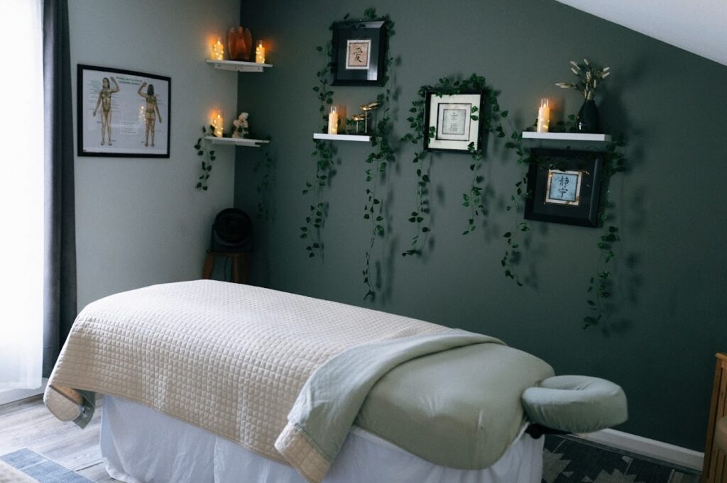 Medical massage therapy room at Pampered Spirit spa in Point Pleasant NJ featuring massage table, calming green walls, and candlelit shelves serving Ocean County clients