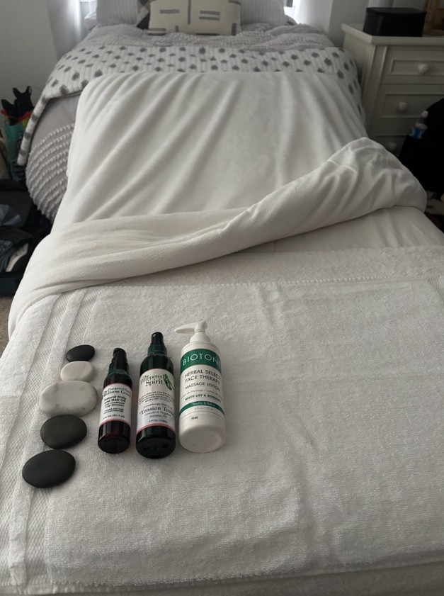 Travel-inspired massage products and hot stones displayed on a treatment table at Pampered Spirit spa in Point Pleasant, New Jersey.